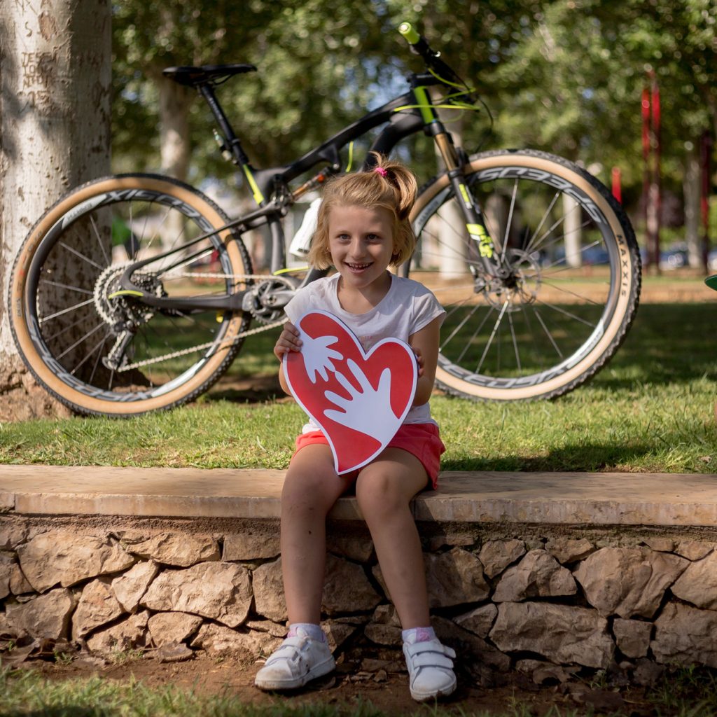 El característico semblante feliz del Síndrome de Angelman Primer plano de Aitana, una niña con Síndrome de Angelman, que muestra una gran sonrisa reflejando el semblante feliz asociado a este trastorno.